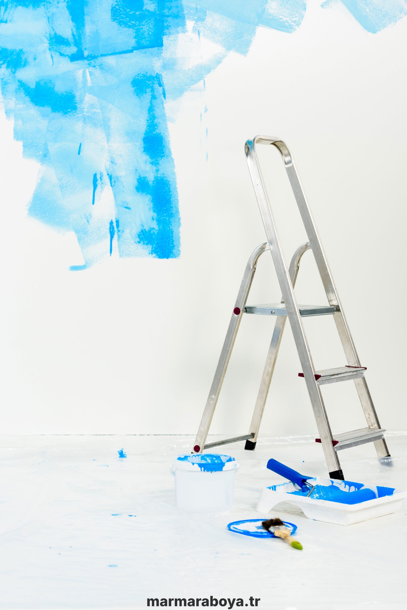 ladder and paint roller brush in blue paint